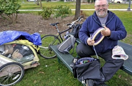 Homeless man loom knits hats for others in need.